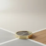 Brass compass at a fork of two minimalist paths on a soft neutral background, symbolizing choosing between vision and market feedback.